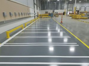 Epoxy Floor Coating for Automotive Facility by Liquid Floors Automotive Epoxy Floor Coating installed by Liquid Floors using Decorative Flakes and Line Striping